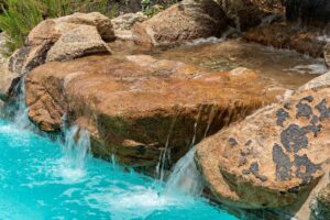 A large rock partially submerged in water, illustrating winterization of a residential water feature.