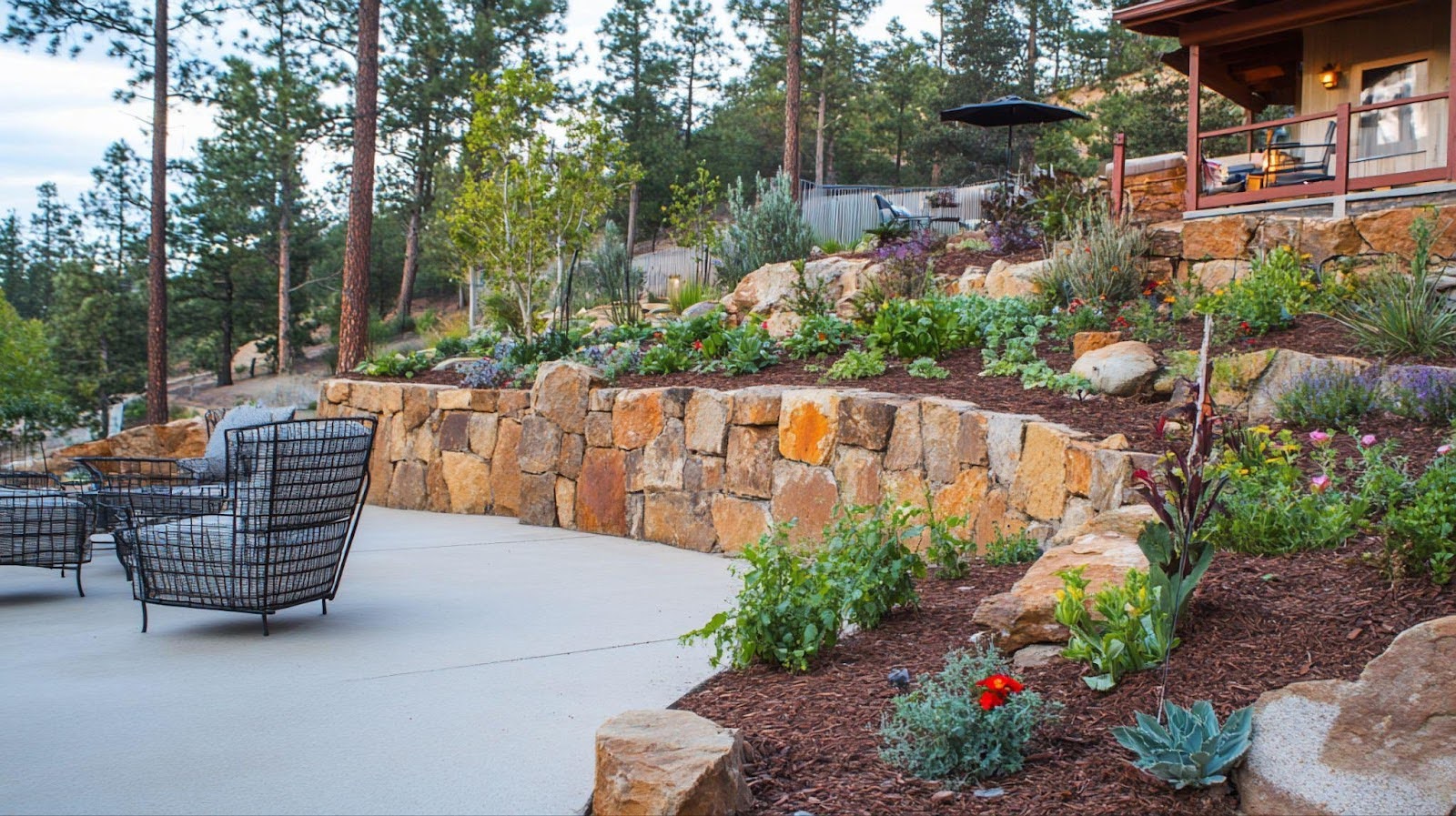 A patio featuring a rock wall and a cozy seating area for relaxation and outdoor gatherings